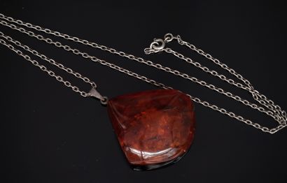 Silver chain holding a pendant formed by...