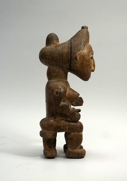 Statuette féminine présentée assise, les...
