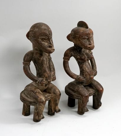 Couple représenté assis sur des tabourets...