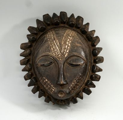 Masque circulaire présentant un visage aux...