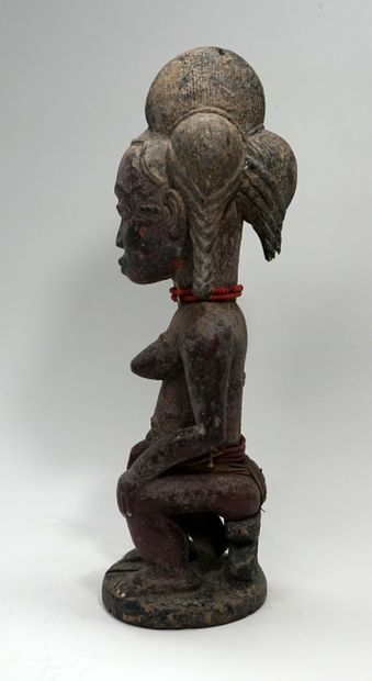 Statuette présentant une femme assise sur...