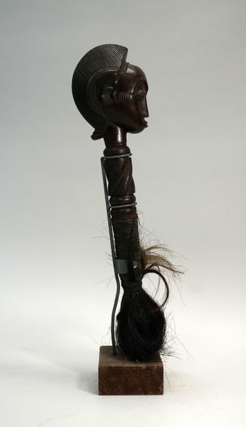 Chasse mouche terminé par une tête coiffée...