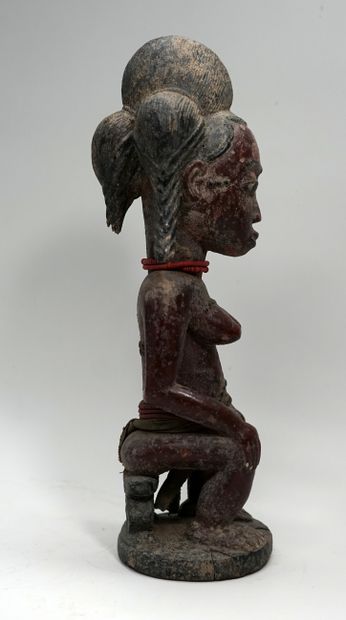 Statuette présentant une femme assise sur...