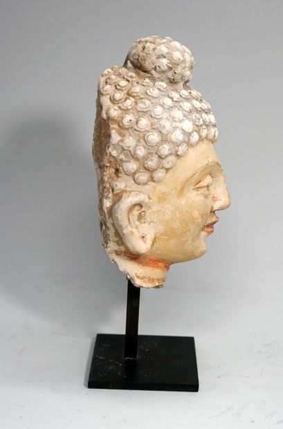 Tête de Bouddha en stuc polychrome, il porte...