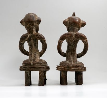 Couple représenté assis sur des tabourets...