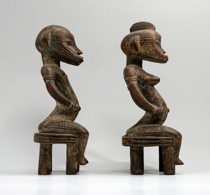 Couple représenté assis sur des tabourets...