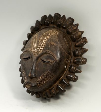 Masque circulaire présentant un visage aux...