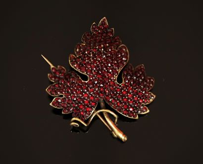 A silver and 18K (750/°°) gold pin featuring...