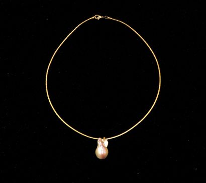 Gilded metal cable necklace holding a baroque...