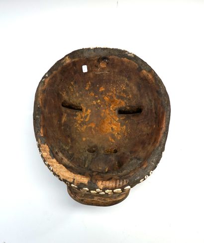 Masque rond aux lèvres proéminentes, en bois...