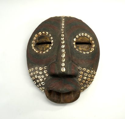 Masque rond aux lèvres proéminentes, en bois...