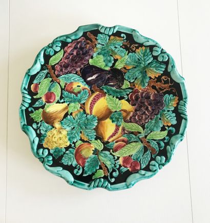 Grand plat en céramique polychrome sur piédouche...