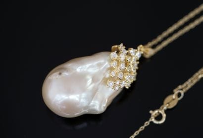 silver necklace holding a large baroque cultured...