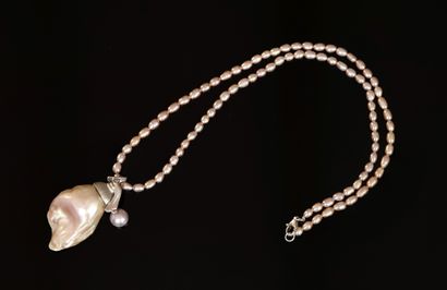NECKLACE of pink freshwater pearls holding...