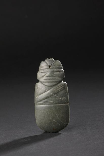 Ceremonial axe-shaped pendant engraved with...