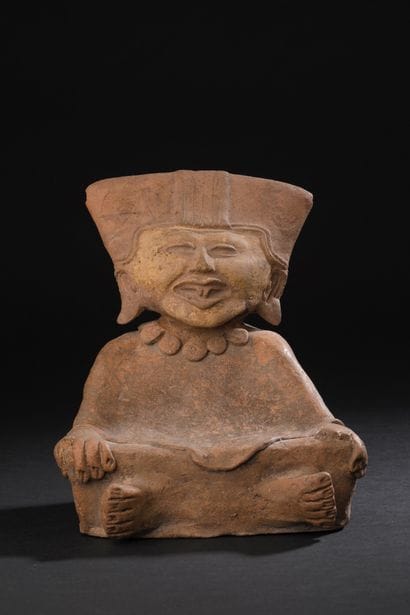 Priest seated cross-legged with hands on...