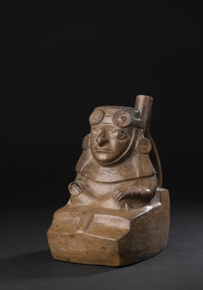Stirrup-handled vase depicting a seated dignitary
atop...