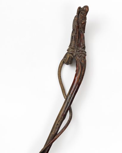 CHINE - VERS 1900
Canne en bois sculpté surmontée...