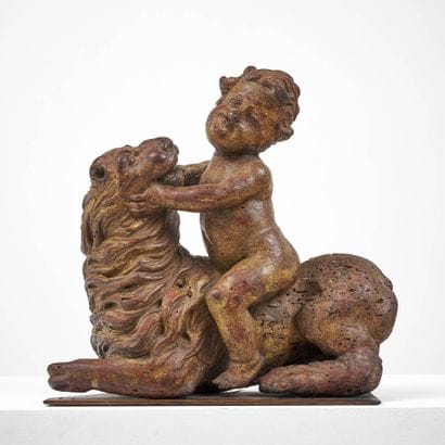 ENFANT CHEVAUCHANT UN LION EN BOIS SCULPTÉ...