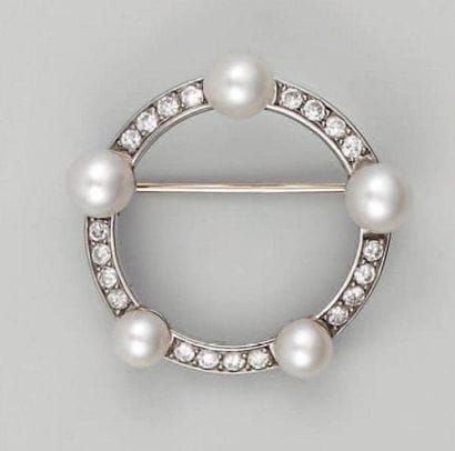 Broche ronde en or gris ajouré, ornée d'une...