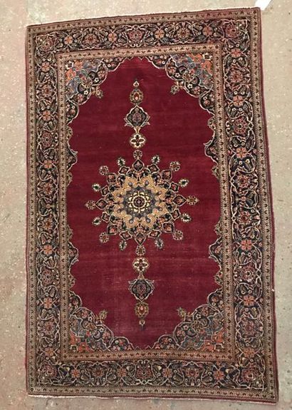 A woollen rug with a central medallion on...