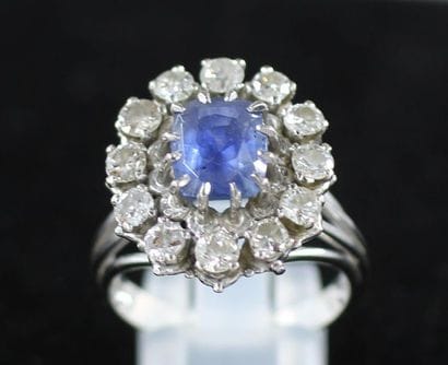 Flower ring in 18k white gold with a blue...