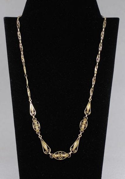 Falling yellow gold necklace with oval openwork...