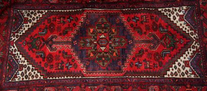 Tapis en laine polychrome à décor d'un médaillon...