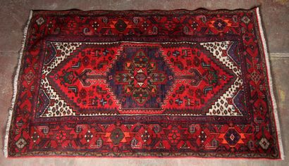 Tapis en laine polychrome à décor d'un médaillon...