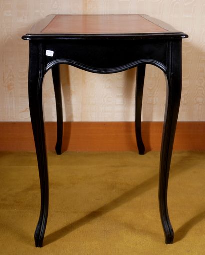 *Table en bois noirçi garnie de cuir rouge,...