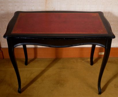 *Table en bois noirçi garnie de cuir rouge,...