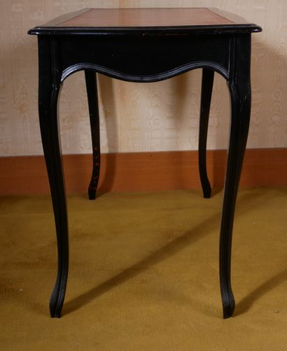 *Table en bois noirçi garnie de cuir rouge,...