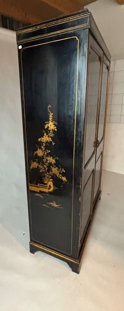 Two-door cabinet in blackened and gilded...