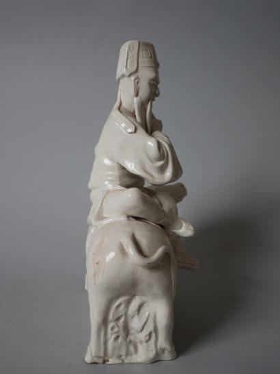 White porcelain statuette of an old man sitting...