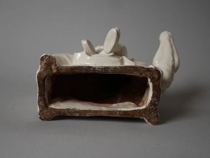 White porcelain statuette of an old man sitting...