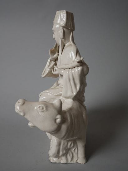 White porcelain statuette of an old man sitting...