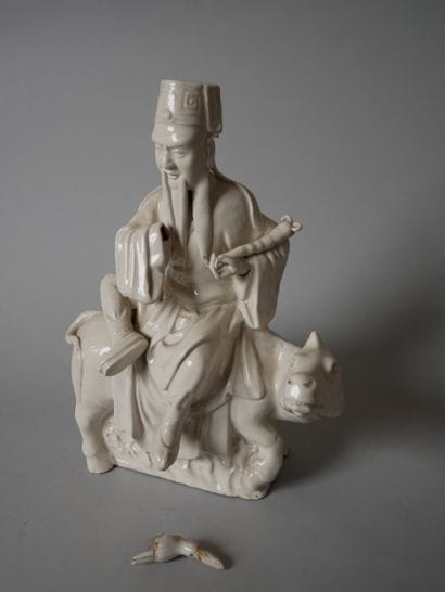 White porcelain statuette of an old man sitting...