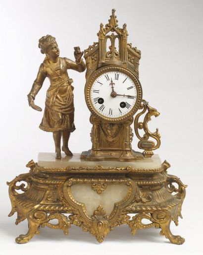 pendule en bronze doré à côté d'une joueuse...
