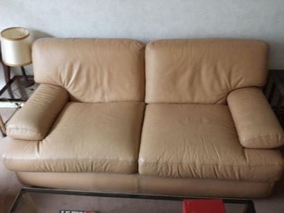 Canapé confortable en cuir beige (usures)...