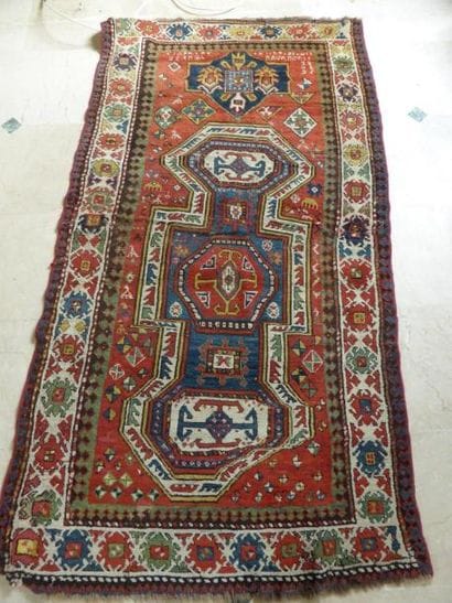 Tapis à fond rouge orné d'un décors géométrique...