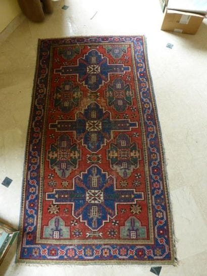 Tapis à fond rouge à trois médaillons cruciformes...