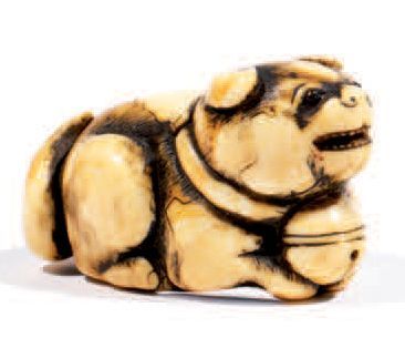 Netsuke en ivoire représentant un chiot couché,...