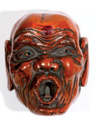 Petit masque en laque rouge représentant...