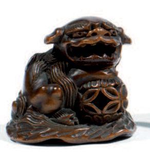 Netsuke en bois un shishi assis, gueule ouverte,...