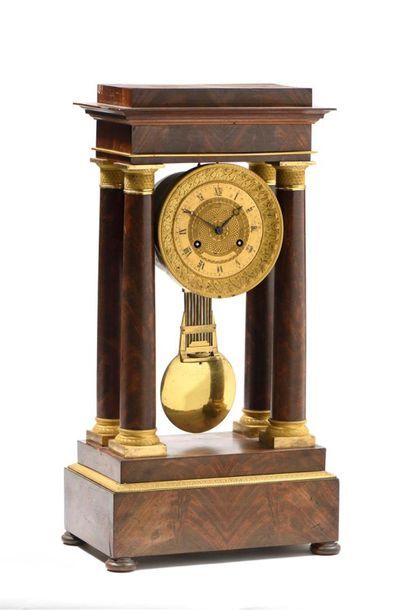Pendule portique en placage d'acajou agrémentée...