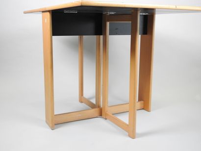 Table à deux volets pliants en bois et stratifié.
Travail...