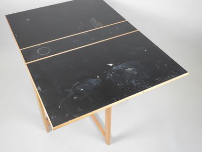 Table à deux volets pliants en bois et stratifié.
Travail...