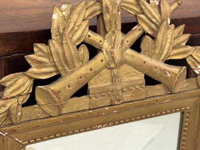 Miroir en bois doré à décor d'attributs de...