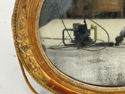 Oval wood and gilded stucco mirror decorated...