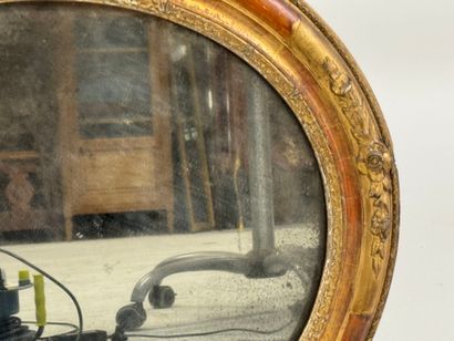 Oval wood and gilded stucco mirror decorated...